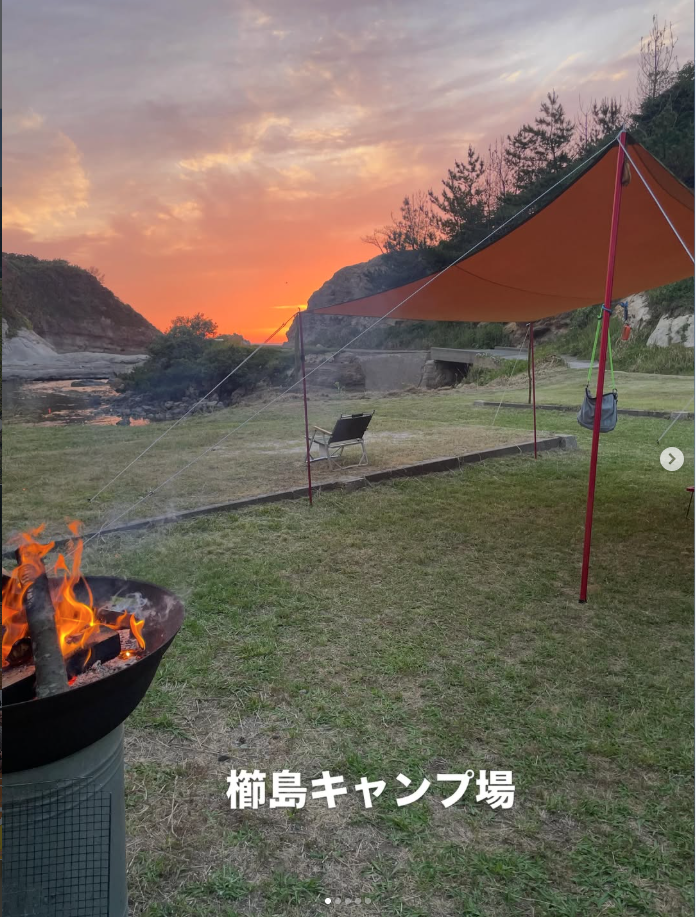 夕焼けの中の焚き火とタープ